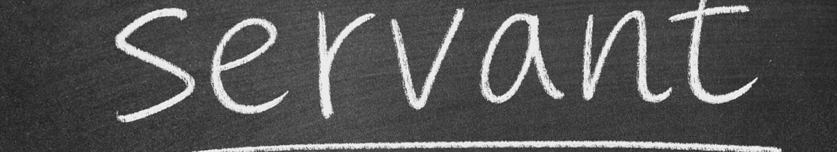 The word 'servant' is written in white chalk on a dark, textured blackboard.